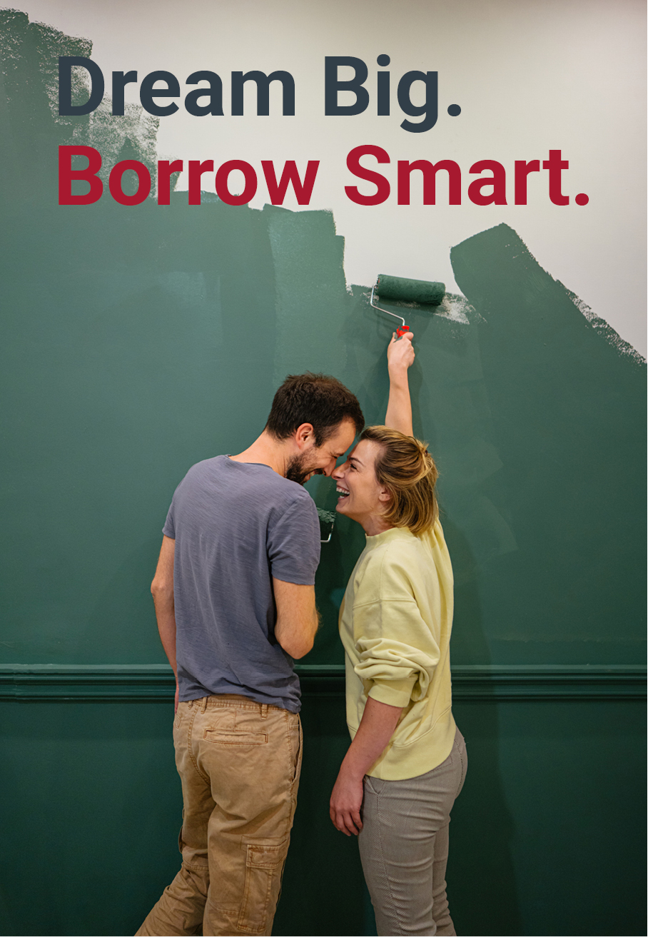 Photo of young couple painting the walls of their new apartment. "Dream Big. Borrow Smart."