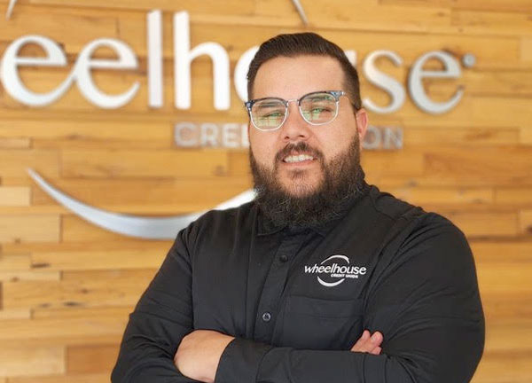Joshua Mehrian standing in front of a wheelhouse sign