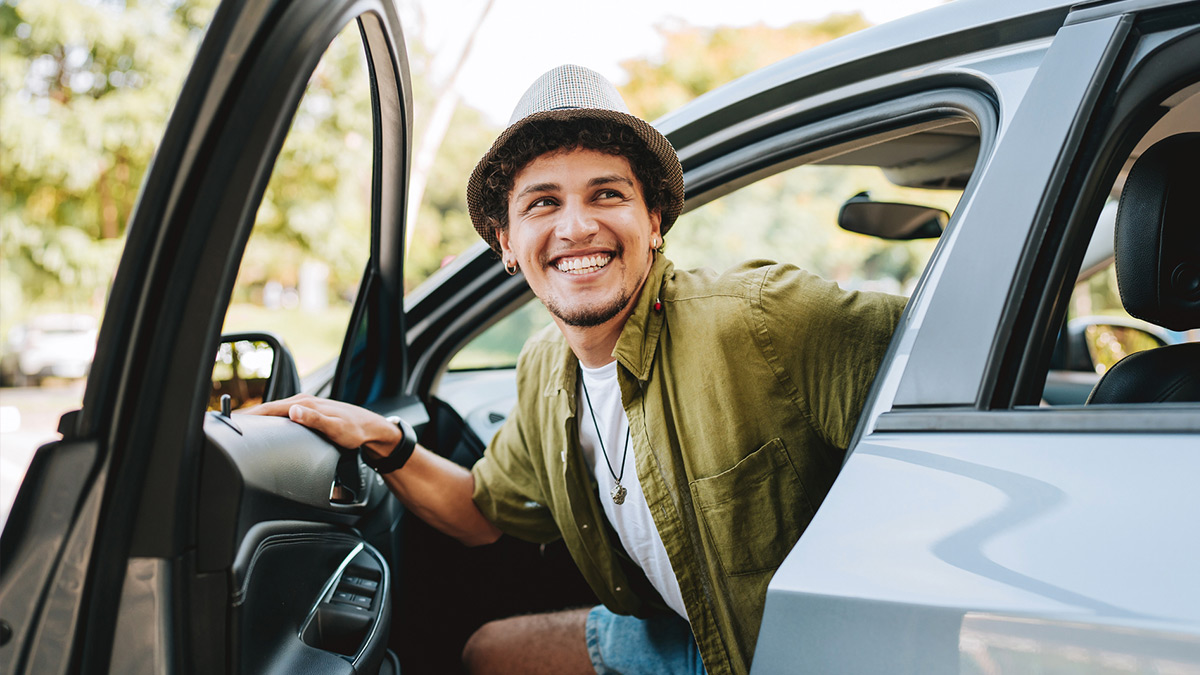Young person smiling while exiting a car.