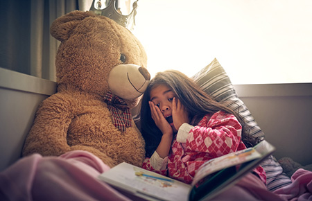 girl storytelling with bear