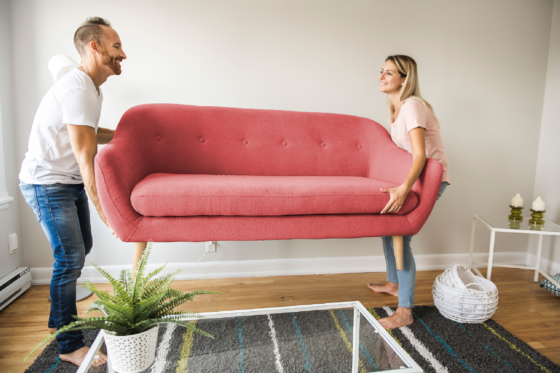 Couple moving couch into home