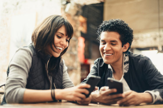 Two person using mobile to pay