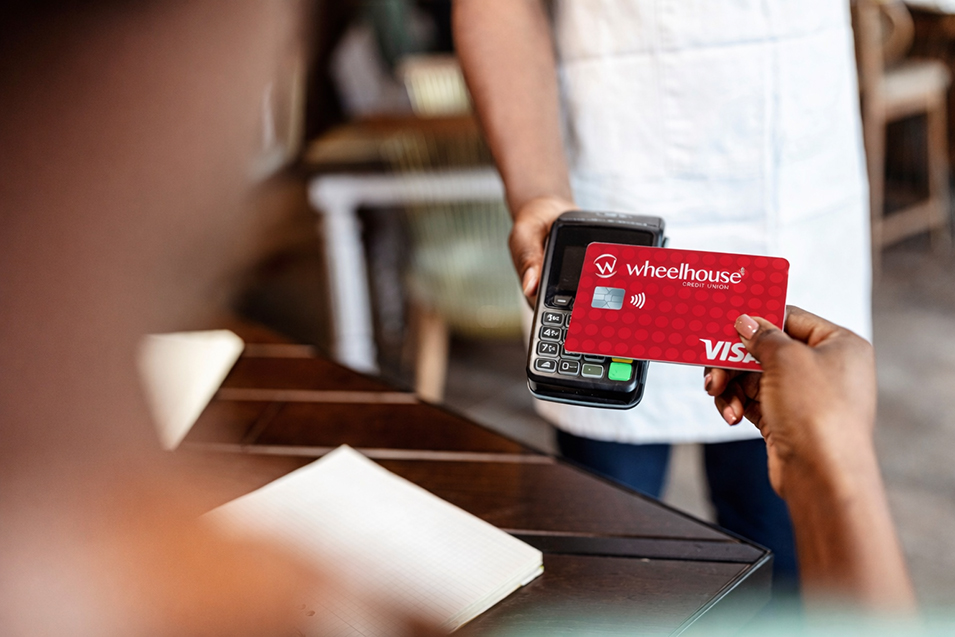 Business woman giving credit card to waiter using modern contactless system at the bar