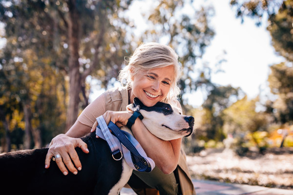 Woman smiling and holding a dog.
