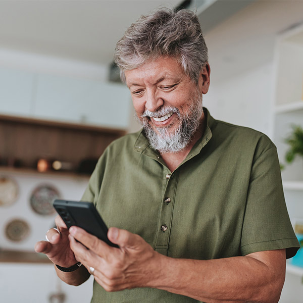 Man smiling while using a smartphone.