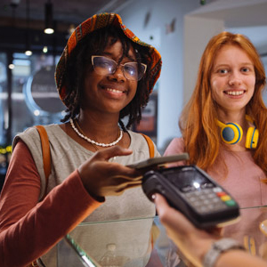 Young woman using her mobile phone to pay at the register.
