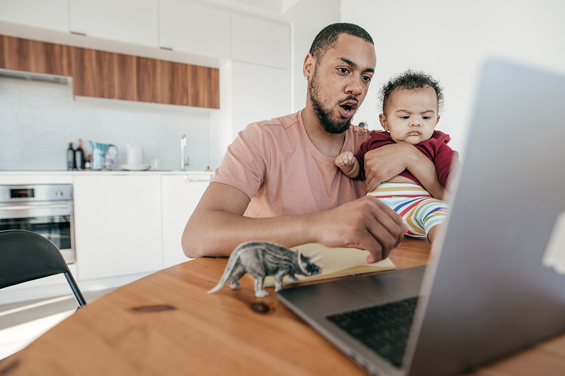 man, baby and toy dinosaur in front of laptop