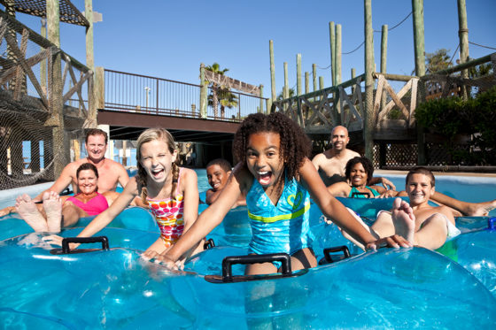 Families on floating inner tubes on water.