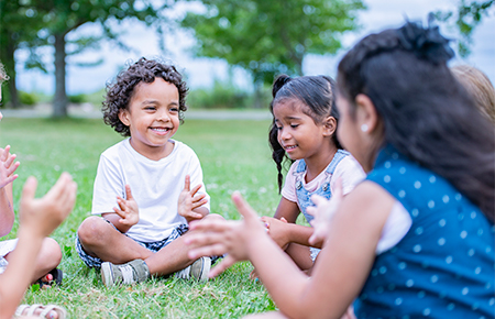 children sitting on grass playing