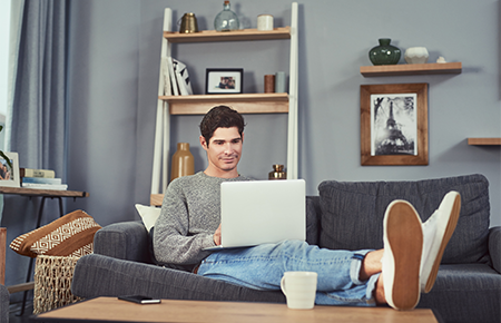 man on couch using laptop