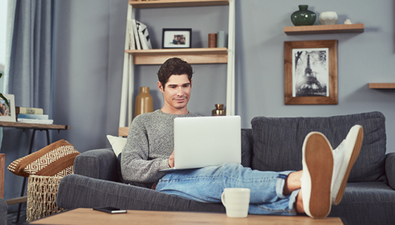 man on couch using laptop