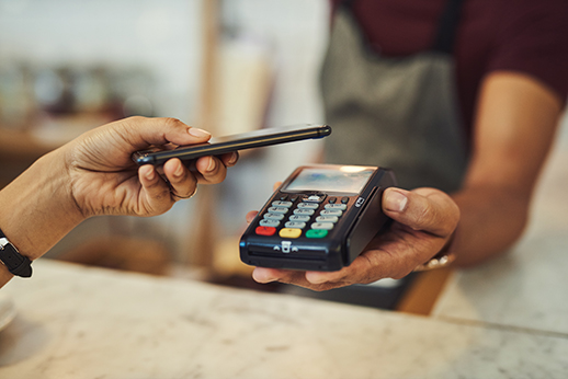 Closeup shot of a customer making a payment with a cellphone in a cafe