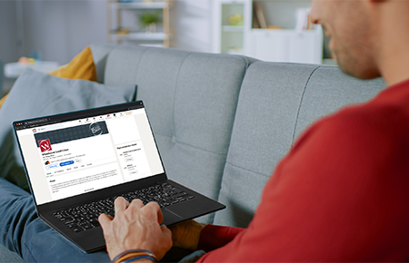 man on couch using laptop