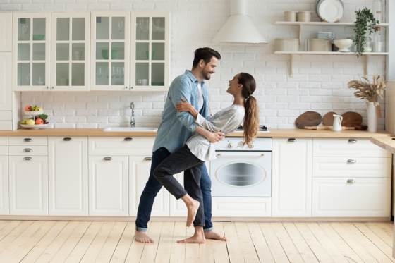 happy couple dancing in home kitchen