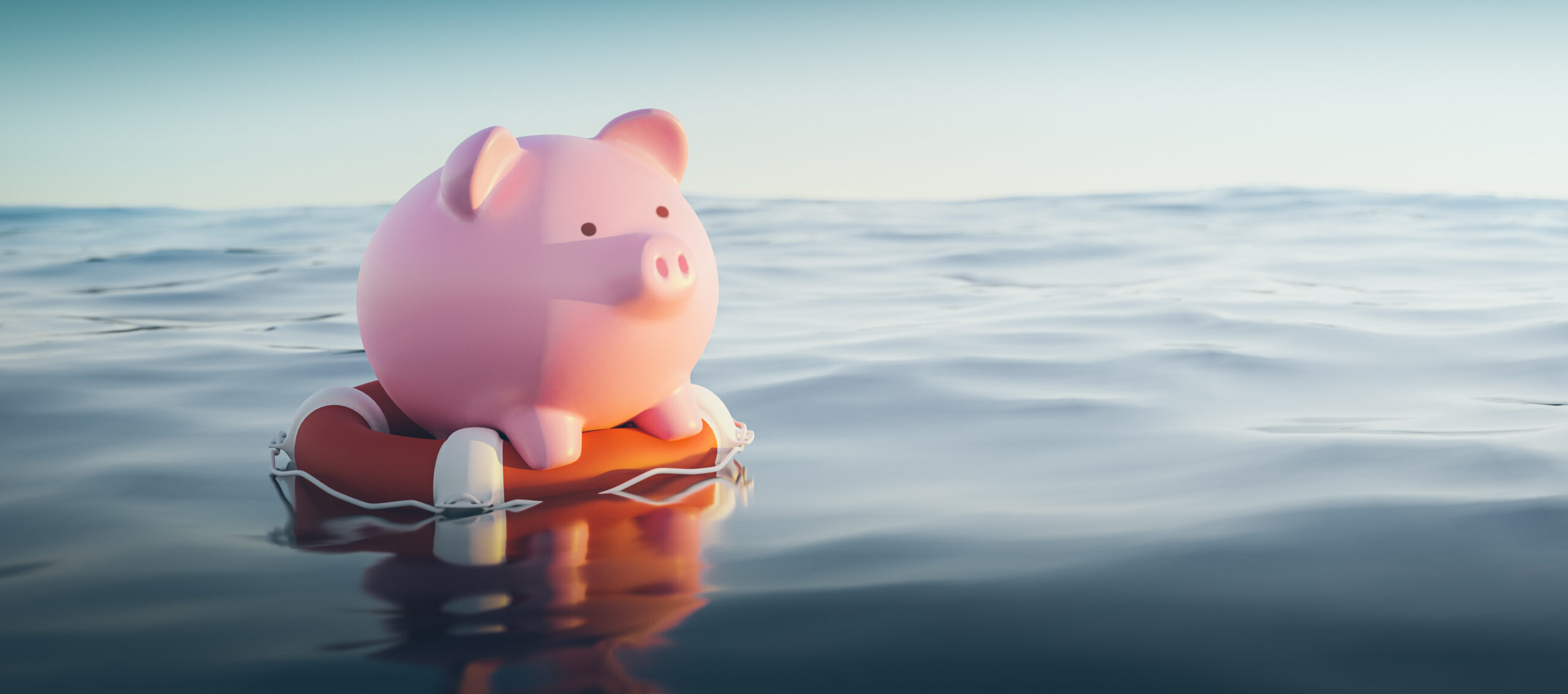 Piggy bank floating in the ocean on a life preserver