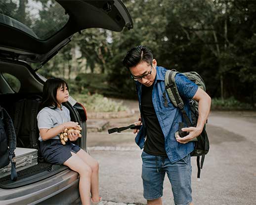 father and daughter at back of car