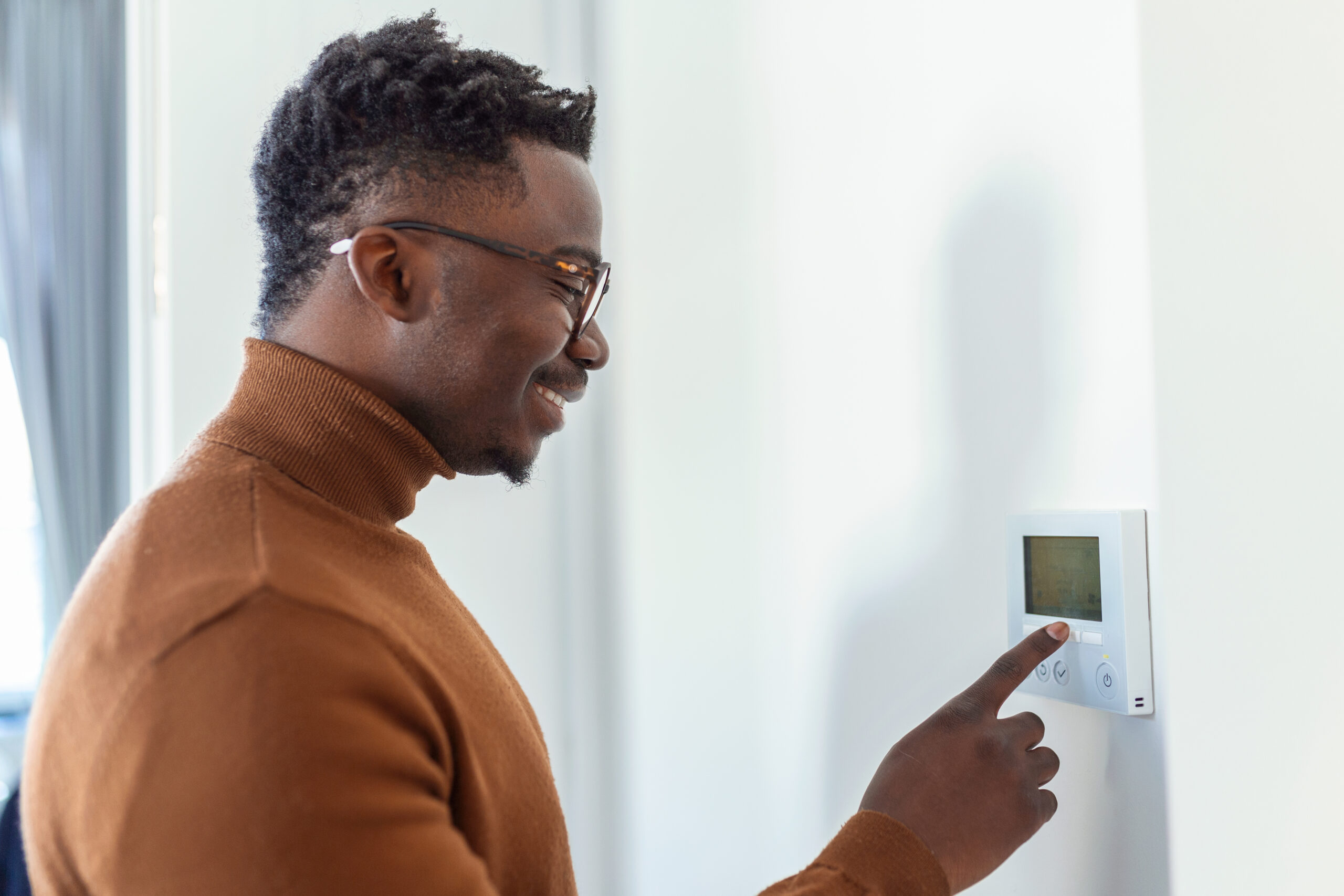 Man adjusting thermostat