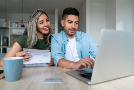 Happy couple at home filing taxes online stock photo