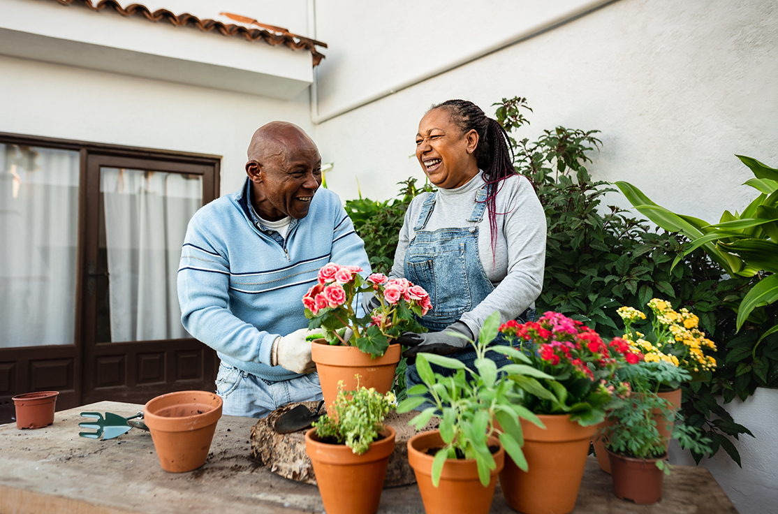 Happy African senior people gardening together at home.