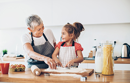 Senior woman and a small girl preparing cookies