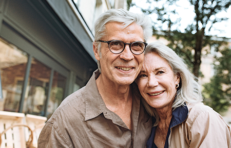 Elderly couple in front of house