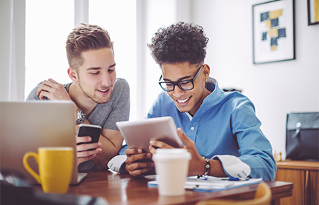 two young men on electronic devices