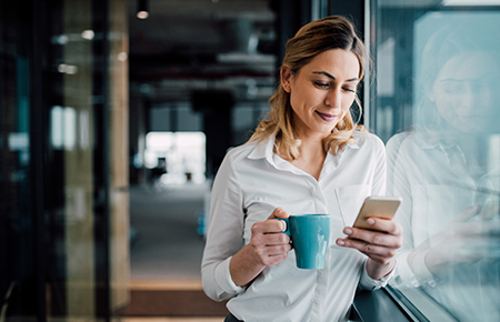 Woman with coffee looking at phone