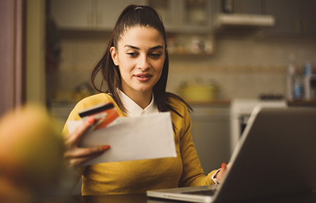 Woman at computer looking at bill