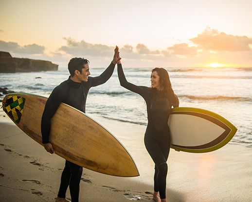 Woman and Man surfers High Fiving