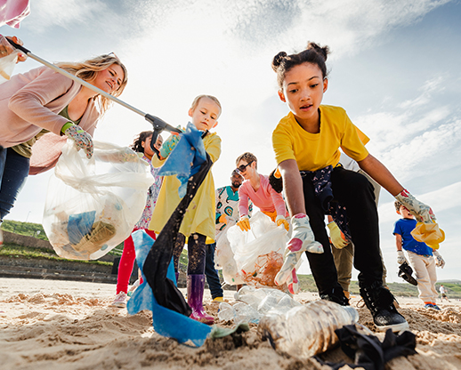 Kids picking up trash on the beach